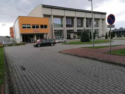 a car parked in a parking lot in front of a building at Pokoje nad Rabą in Myślenice