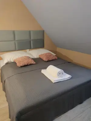 a bed with two pillows and a towel on it at Pokoje nad Rabą in Myślenice