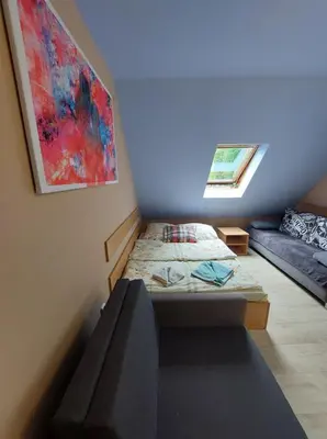 a small room with two beds and a window at Pokoje nad Rabą in Myślenice