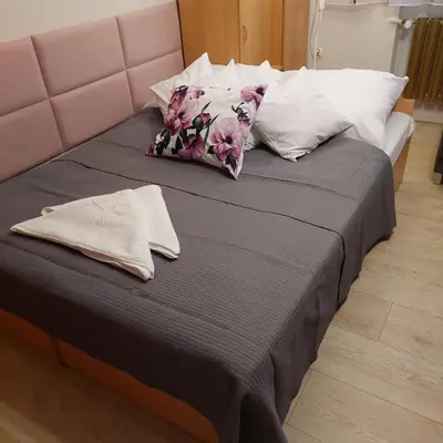 a bed with a pink headboard and pillows on it at Pokoje nad Rabą in Myślenice