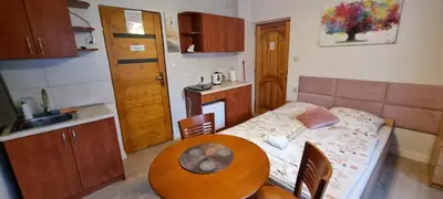 a small kitchen with a table and a small kitchen with a table and a table at Pokoje nad Rabą in Myślenice