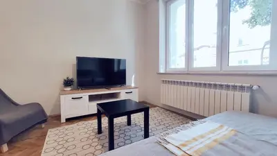 a living room with a tv and a bed and a table at Barska 21 by Homeprime in Kraków
