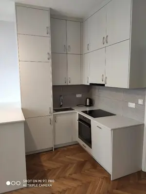 a white kitchen with white cabinets and a sink at Barska 21 by Homeprime in Kraków