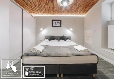 a bedroom with a large bed with a wooden ceiling at M3 Main Square Studio in Kraków