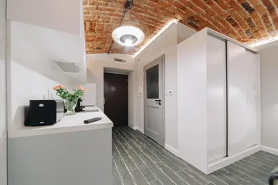 an office with white cabinets and a brick wall at M3 Main Square Studio in Kraków