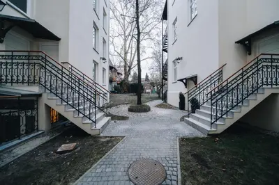 a walkway between two buildings with a tree and stairs at M3 Main Square Studio in Kraków