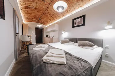 a bedroom with a large bed with towels on it at M2 Main Square Studio in Kraków