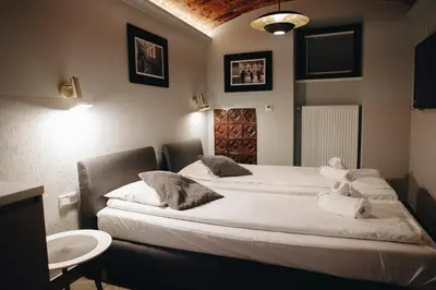 a hotel room with two beds and a sink at M2 Main Square Studio in Kraków