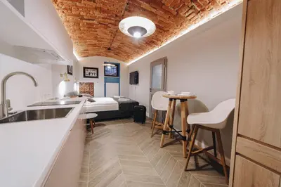 a kitchen with a sink and a bed in a room at M2 Main Square Studio in Kraków