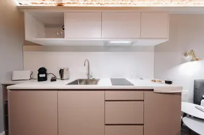 a kitchen with white cabinets and a sink at M2 Main Square Studio in Kraków