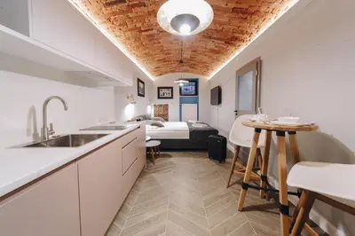 a kitchen and dining room with a bed in the background at M2 Main Square Studio in Kraków