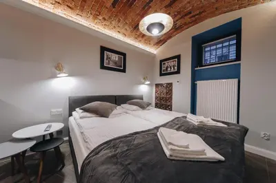 a bedroom with a large bed with a table and a table at M2 Main Square Studio in Kraków
