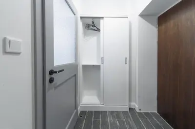 a hallway with a white door and a wooden floor at M4 Main Square Studio in Kraków