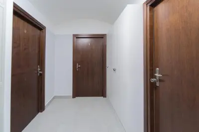 an empty hallway with two wooden doors and a floor at M4 Main Square Studio in Kraków