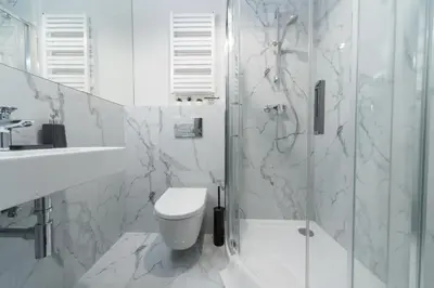 a white bathroom with a toilet and a shower at M4 Main Square Studio in Kraków