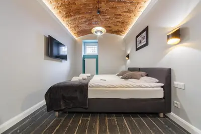 a bedroom with a bed in the corner of a room at M4 Main Square Studio in Kraków