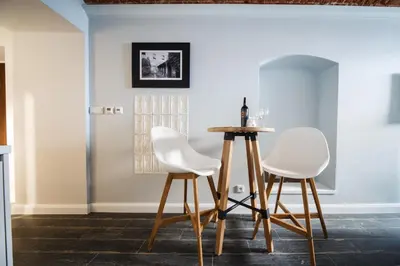 a dining room with two white chairs and a table at M4 Main Square Studio in Kraków