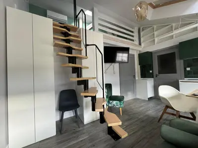 a living room with a spiral staircase and chairs at Forest Nook Main Square Loft in Kraków