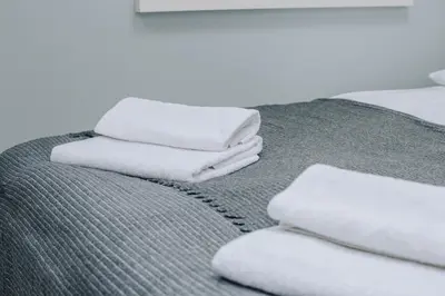 a pile of towels sitting on top of a bed at Forest Nook Main Square Loft in Kraków