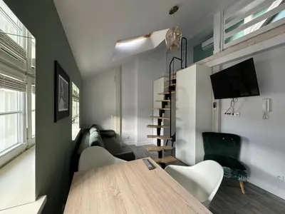 a living room with a table and chairs and a tv at Forest Nook Main Square Loft in Kraków