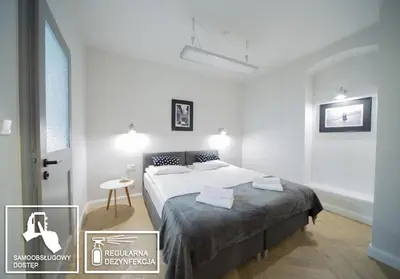 a white bedroom with a bed and a table at M5 Main Square Stylish One Bedroom in Kraków