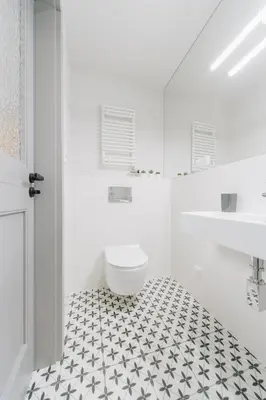 a bathroom with a toilet and a black and white tile floor at M5 Main Square Stylish One Bedroom in Kraków
