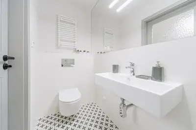 a white bathroom with a sink and a toilet at M5 Main Square Stylish One Bedroom in Kraków