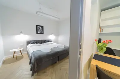 a bedroom with a bed and a table in a room at M5 Main Square Stylish One Bedroom in Kraków