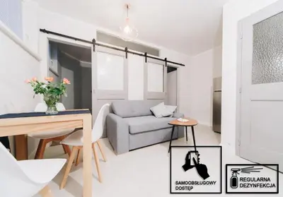 a living room with a couch and a table at M6 Main Square Stylish One Bedroom in Kraków