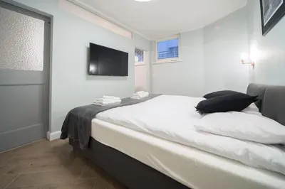 a bedroom with a bed with a tv on the wall at M6 Main Square Stylish One Bedroom in Kraków
