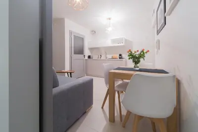 a living room and kitchen with a table and a couch at M6 Main Square Stylish One Bedroom in Kraków