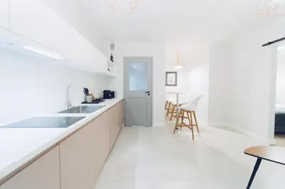 a white kitchen with a sink and a table at M7 Main Square with Free Parking Friends Escape in Kraków