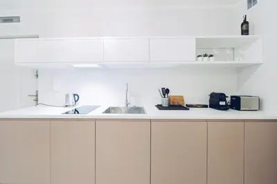 a white kitchen with white cabinets and a sink at M7 Main Square with Free Parking Friends Escape in Kraków