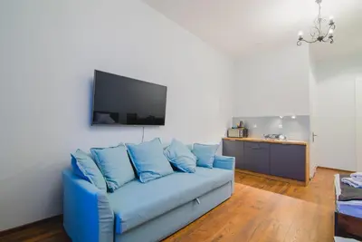 a blue couch in a living room with a flat screen tv at Oak Tree Old Town Apartments in Kraków