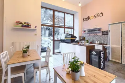 a restaurant with tables and chairs and a kitchen at Native Apartments Starowiślna 33A Deluxe in Kraków