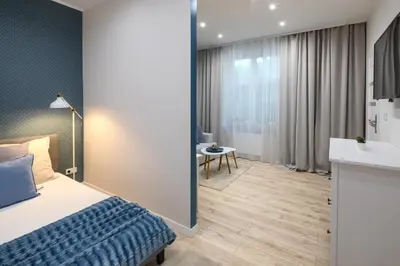 a hotel room with a bed and a bathroom at Native Apartments Starowiślna 33A Deluxe in Kraków