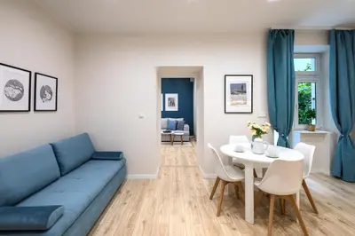 a living room with a blue couch and a table at Native Apartments Starowiślna 33A Deluxe in Kraków