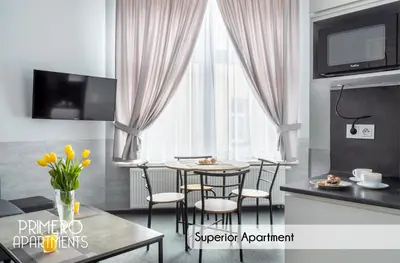 a living room with a table and chairs in front of a window at PRIMERO Elegant Apartments KRAKÓW Old Town in Kraków