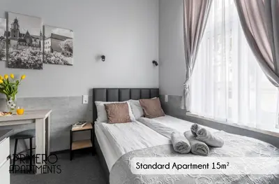 a bedroom with a bed with towels on it at PRIMERO Elegant Apartments KRAKÓW Old Town in Kraków