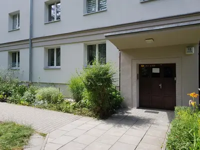 a white house with a brown door and a sidewalk at Cracowapart Ignacio B in Kraków