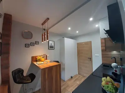 a small kitchen with a counter and a chair at Cracowapart Ignacio B in Kraków