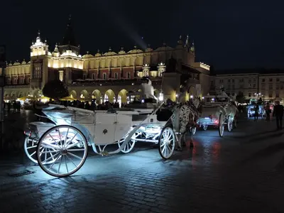 a horse drawn carriage parked in front of a building at Cracowapart Ignacio B in Kraków