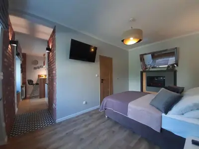 a bedroom with a bed and a tv on the wall at Cracowapart Ignacio B in Kraków