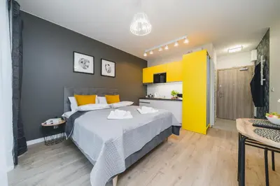 a bedroom with a bed and a yellow wall at Sarah Apartments Old Town in Kraków