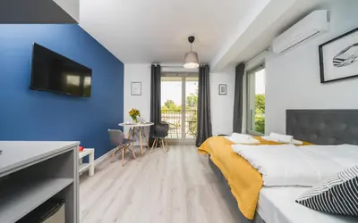 a bedroom with a bed and a tv and a table at Sarah Apartments Old Town in Kraków