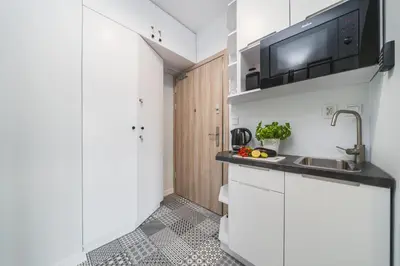 a small kitchen with a sink and a microwave at Sarah Apartments Old Town in Kraków