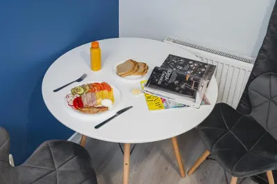 a white table with a plate of food on it at Sarah Apartments Old Town in Kraków