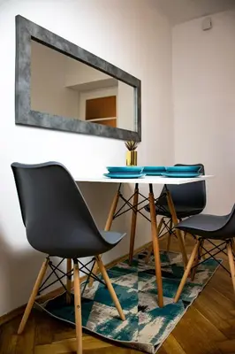 a dining table with two chairs and a mirror at Royal flats Old Town in Kraków