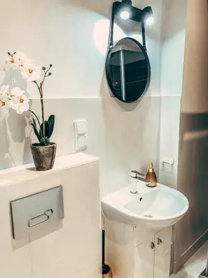 a white bathroom with a sink and a mirror at Royal flats Old Town in Kraków