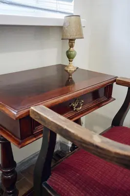 a wooden desk with a lamp and a chair at 29 Avenue Apartments in Kraków